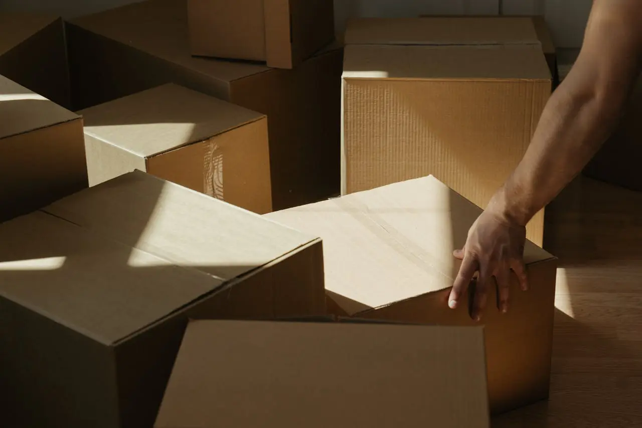 A person arranging cardboard boxes while packing