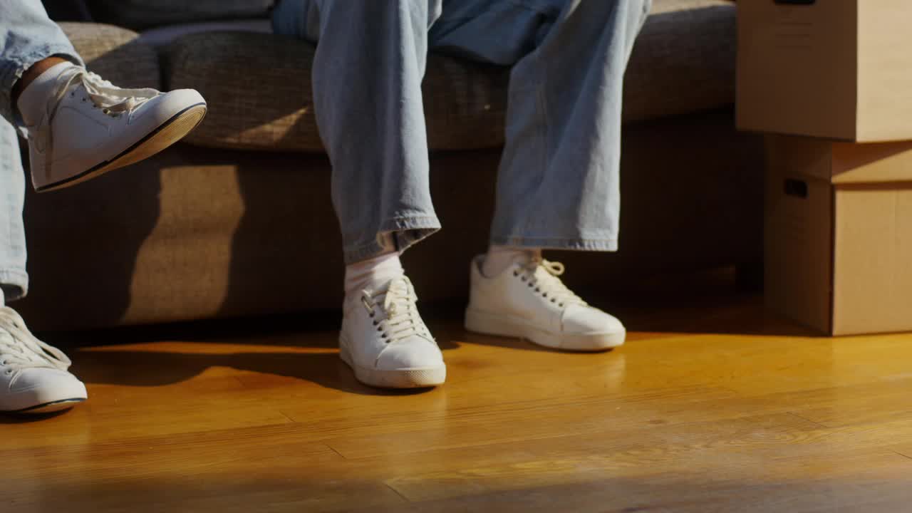 Illustrative photo of people seated beside moving boxes